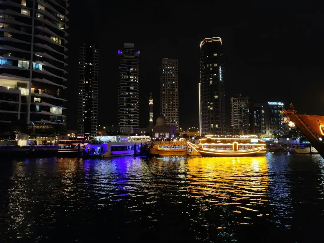 Dubai Marina towers lit at night over the water